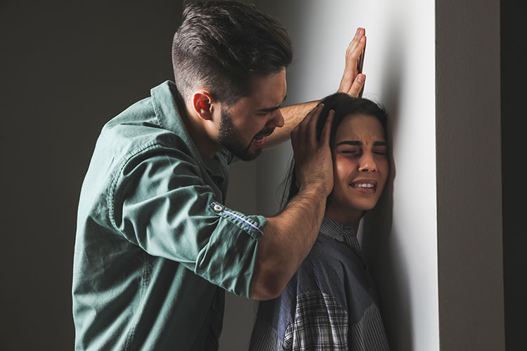 Man forcing young woman again a wall.